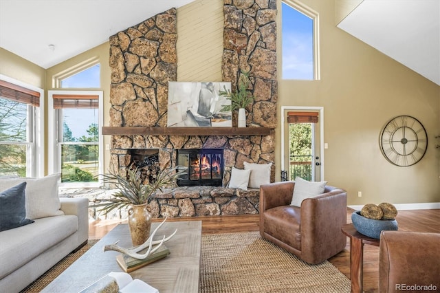 living area with high vaulted ceiling, a fireplace, wood finished floors, and baseboards