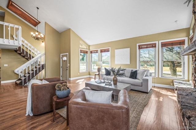 living area with baseboards, stairway, wood finished floors, and an inviting chandelier