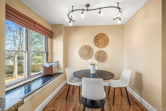 dining space with wood finished floors and baseboards