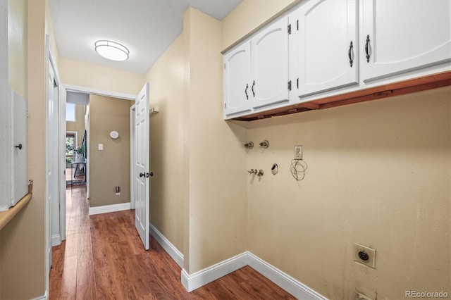 clothes washing area with cabinet space, baseboards, hookup for an electric dryer, and wood finished floors