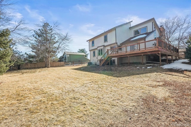 back of house featuring a deck, fence, stairs, a lawn, and a chimney