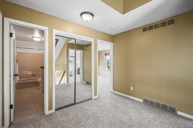 unfurnished bedroom with baseboards, visible vents, and carpet flooring