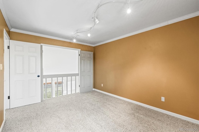 unfurnished bedroom featuring baseboards, carpet flooring, rail lighting, and crown molding