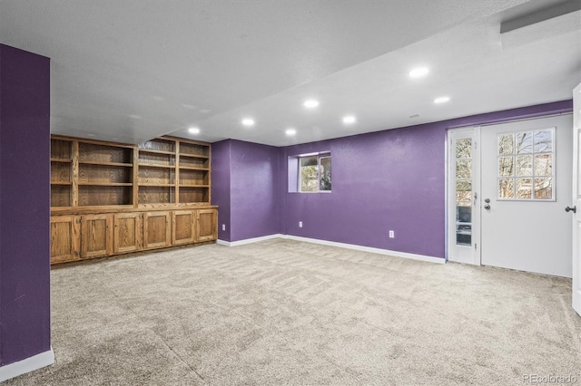 unfurnished living room featuring recessed lighting, light colored carpet, and baseboards