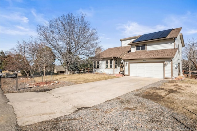 view of front of house with a garage, solar panels, concrete driveway, a chimney, and roof with shingles