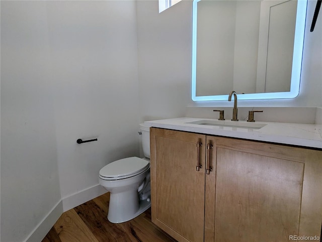 bathroom with hardwood / wood-style floors, vanity, and toilet