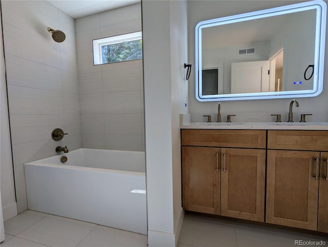 bathroom with tile patterned flooring, vanity, and tiled shower / bath