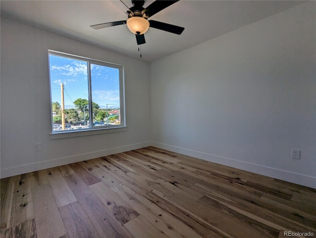 spare room featuring ceiling fan, light hardwood / wood-style floors, and a wealth of natural light