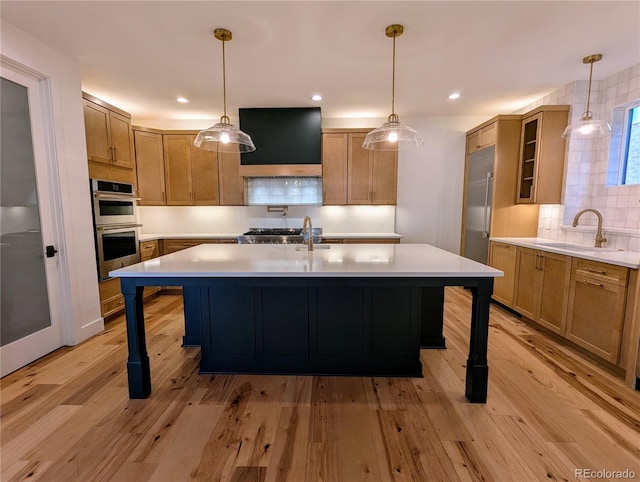 kitchen with pendant lighting, sink, and a kitchen island with sink