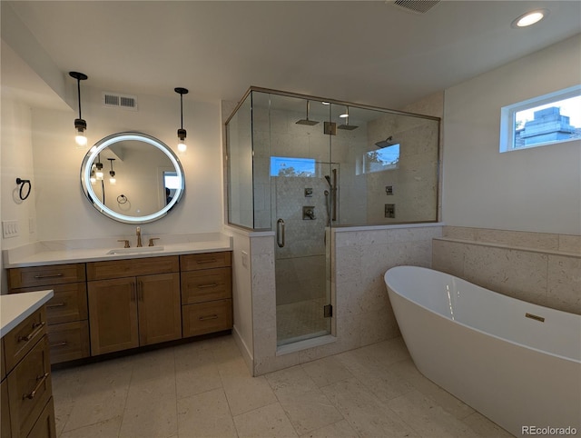 bathroom featuring vanity and independent shower and bath