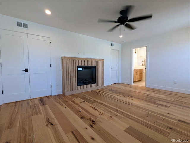 unfurnished living room featuring ceiling fan and light hardwood / wood-style floors