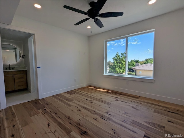 unfurnished bedroom featuring ceiling fan, light wood-type flooring, and sink