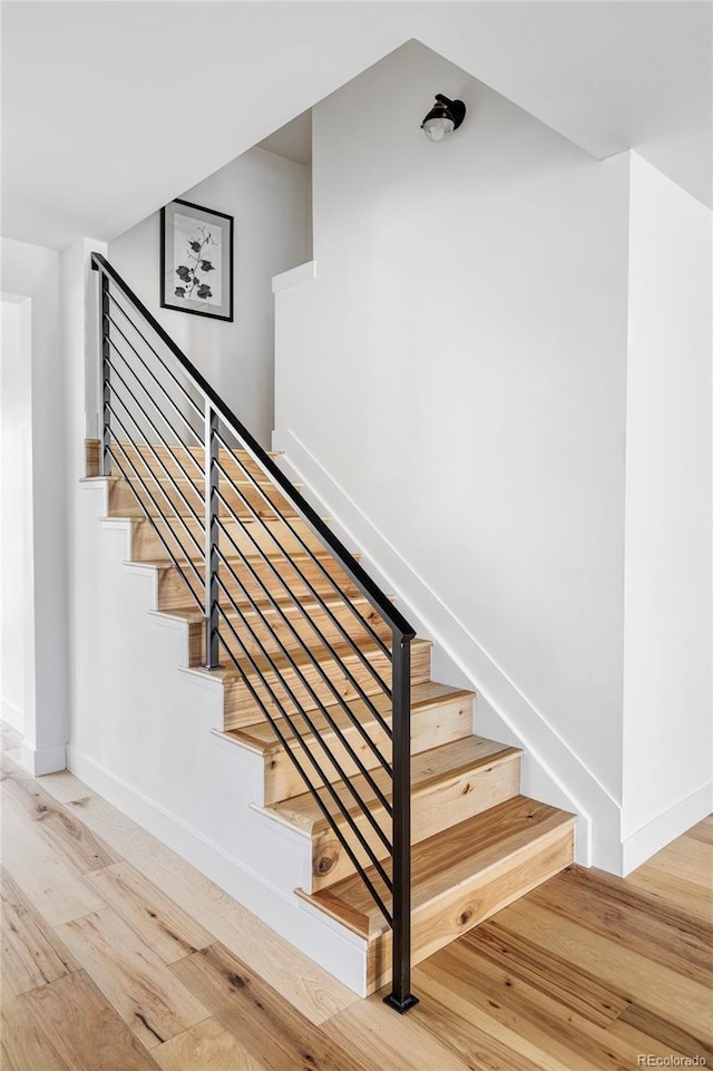 stairway with baseboards and wood finished floors