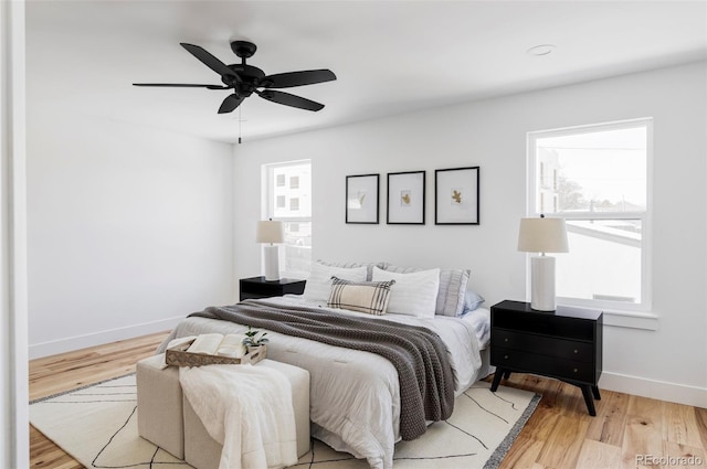 bedroom featuring light wood-type flooring, a ceiling fan, and baseboards