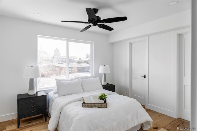 bedroom with light wood-type flooring, a closet, and multiple windows