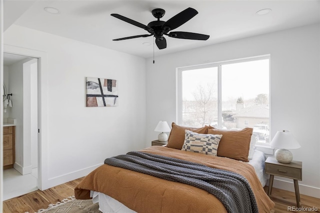 bedroom featuring light wood-type flooring, a ceiling fan, and baseboards