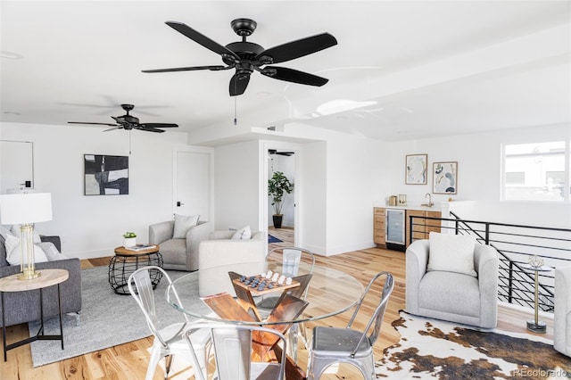 living area featuring wine cooler, wood finished floors, and baseboards