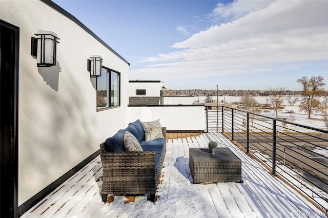 snow covered back of property with outdoor lounge area