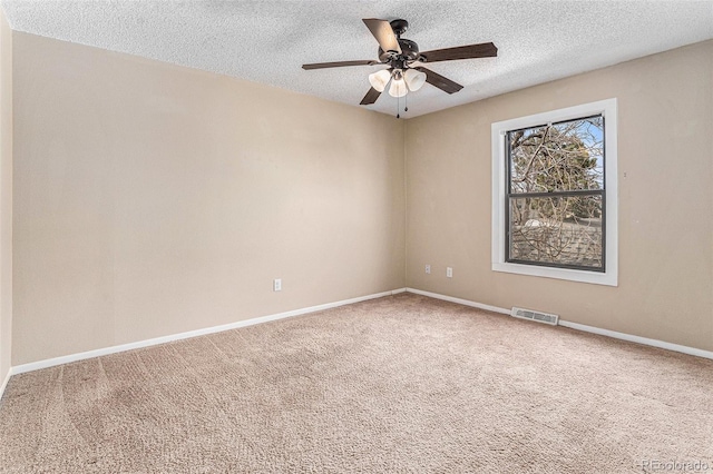 unfurnished room featuring a textured ceiling, carpet, visible vents, and baseboards