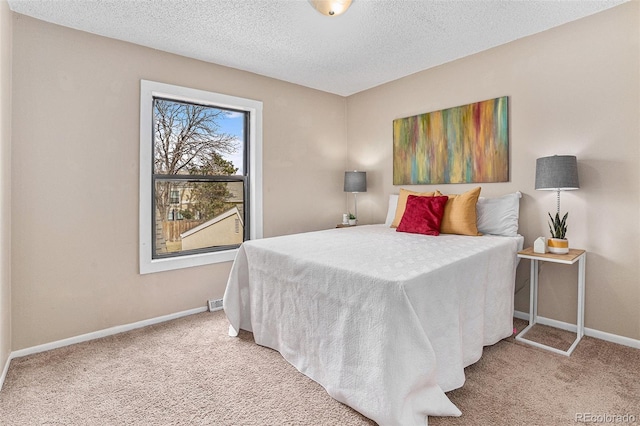 carpeted bedroom featuring a textured ceiling and baseboards