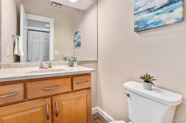 half bath with toilet, baseboards, visible vents, and vanity