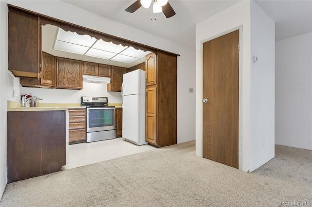 kitchen featuring electric stove, ceiling fan, sink, and white refrigerator