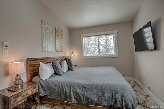 carpeted bedroom featuring baseboards and vaulted ceiling