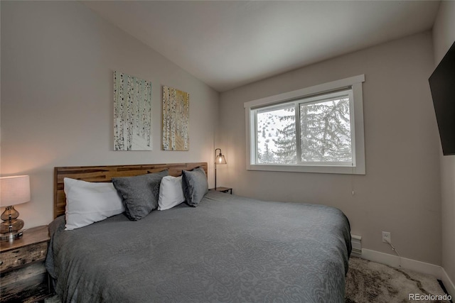 bedroom with baseboards, carpet flooring, and lofted ceiling