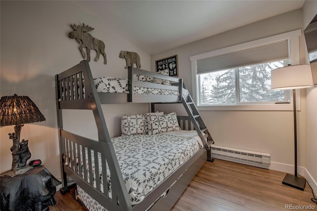 bedroom featuring wood finished floors and baseboard heating