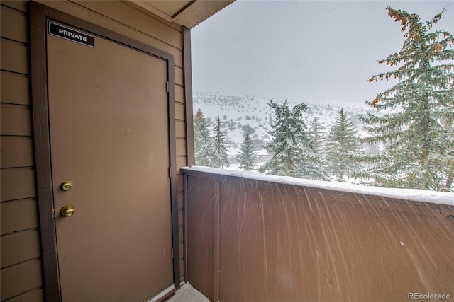 view of snow covered back of property