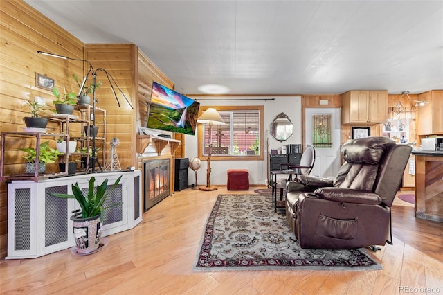 9129 Rampart St, Denver, CO 80260 - living area featuring plenty of natural light, a glass covered fireplace, wood walls, and wood finished floors