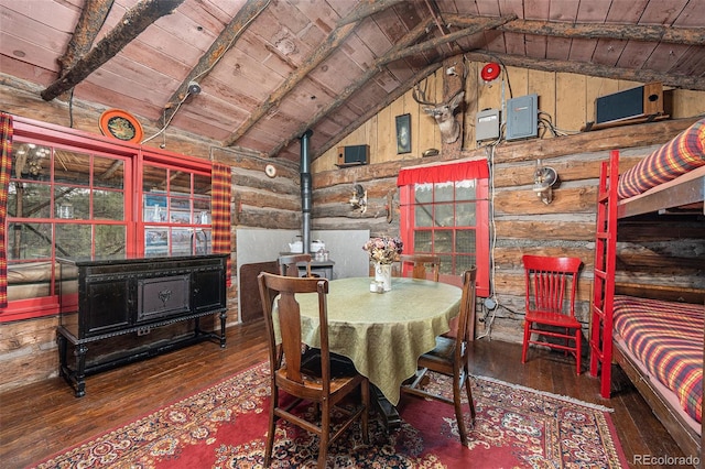 dining space with lofted ceiling with beams, wood-type flooring, a wood stove, and wood ceiling