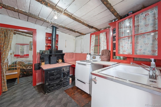 interior space with sink, dark carpet, and a wood stove