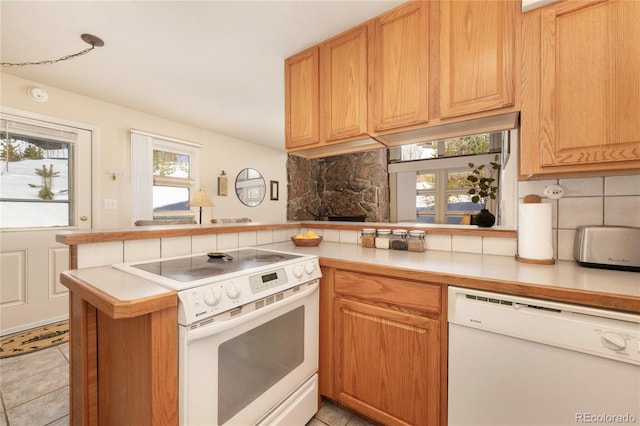 217 Van Anderson Dr Unit 6, Winter Park, CO 80482 - kitchen with light tile patterned floors, light countertops, backsplash, white appliances, and a peninsula