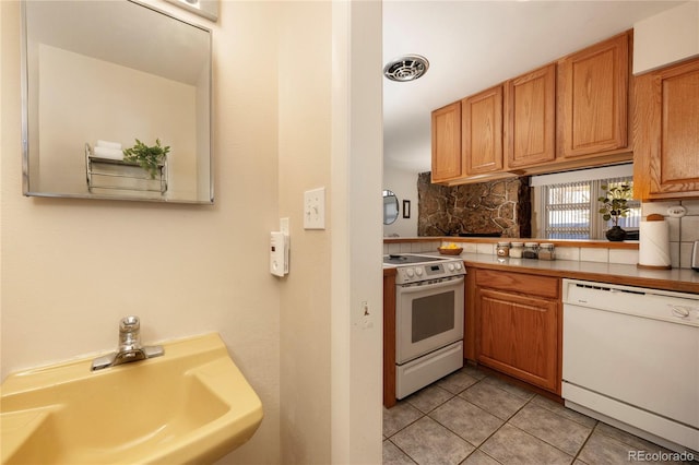 217 Van Anderson Dr Unit 6, Winter Park, CO 80482 - kitchen with light tile patterned floors, white appliances, a sink, visible vents, and backsplash