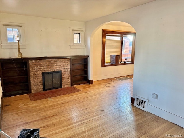 unfurnished living room with a fireplace and light hardwood / wood-style floors