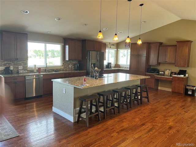 1495 Goldsmith Dr, Highlands Ranch, CO 80126 - kitchen featuring appliances with stainless steel finishes, healthy amount of natural light, a center island with sink, tasteful backsplash, and lofted ceiling