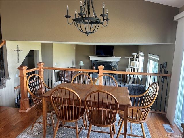1495 Goldsmith Dr, Highlands Ranch, CO 80126 - dining room with a chandelier, wood finished floors, and a fireplace