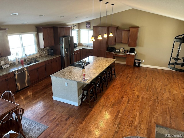 1495 Goldsmith Dr, Highlands Ranch, CO 80126 - kitchen featuring stainless steel appliances, a breakfast bar, hanging light fixtures, lofted ceiling, and dark wood-style flooring