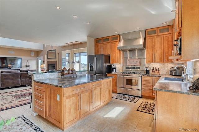 kitchen with light tile patterned flooring, a kitchen island, appliances with stainless steel finishes, sink, and wall chimney exhaust hood