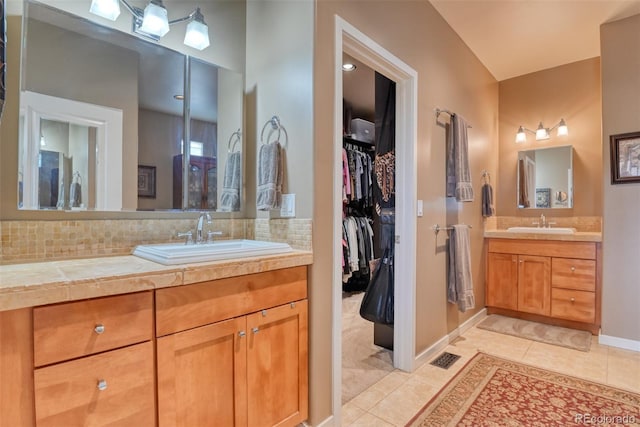 bathroom with tile patterned flooring, vanity, and backsplash