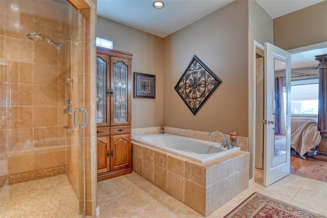 bathroom with tile patterned flooring and separate shower and tub