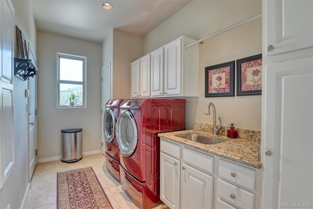 washroom with light tile patterned flooring, cabinets, sink, and washing machine and clothes dryer