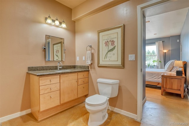 bathroom with toilet, vanity, and concrete floors