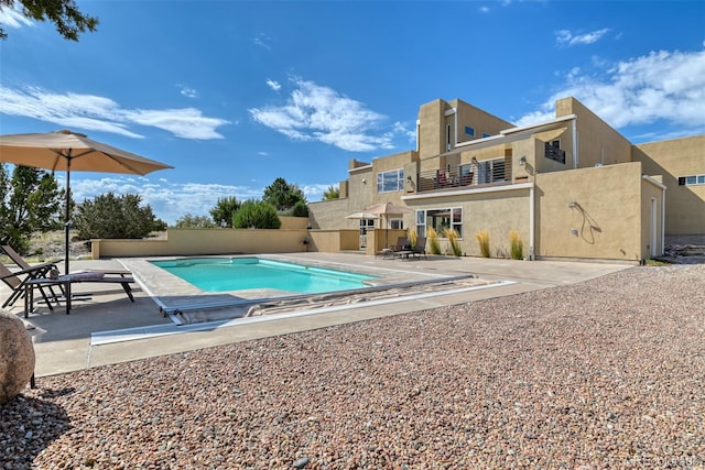 view of pool with a diving board and a patio