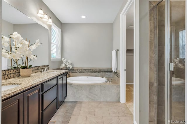 540 E Fremont Pl, Centennial, CO 80122 - full bathroom with double vanity, a garden tub, a stall shower, tile patterned flooring, and backsplash