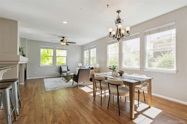 14247 W 84th Cir Unit A, Arvada, CO 80005 - dining room featuring wood finished floors, a chandelier, a ceiling fan, recessed lighting, and a fireplace
