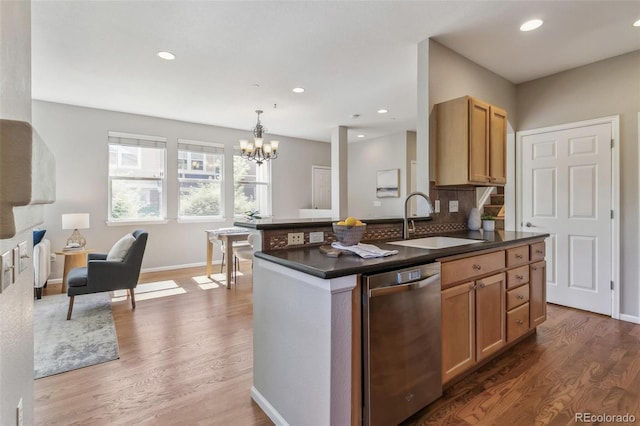 14247 W 84th Cir Unit A, Arvada, CO 80005 - kitchen with stainless steel dishwasher, dark countertops, wood finished floors, a chandelier, and recessed lighting