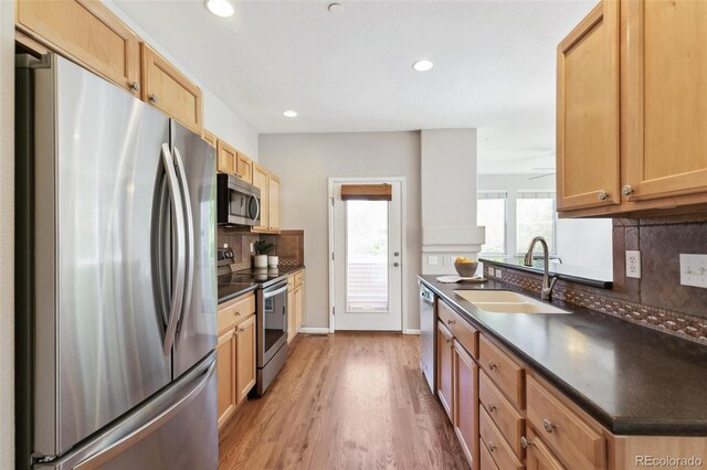 14247 W 84th Cir Unit A, Arvada, CO 80005 - kitchen with stainless steel appliances, dark countertops, tasteful backsplash, light wood-style floors, and recessed lighting