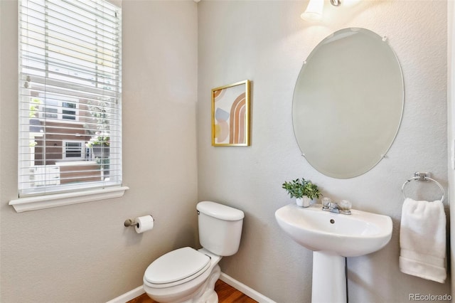 14247 W 84th Cir Unit A, Arvada, CO 80005 - half bathroom featuring toilet and wood finished floors